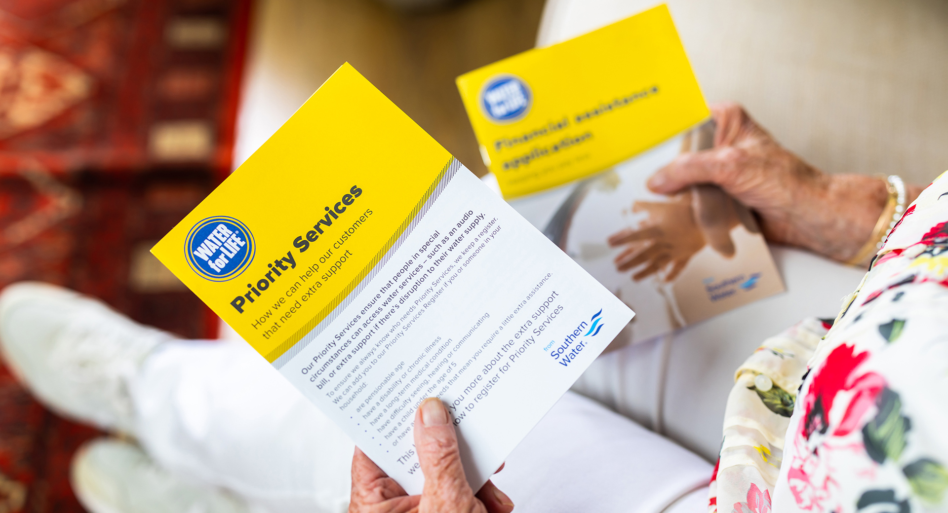 An elderly person reading a letter about priority services