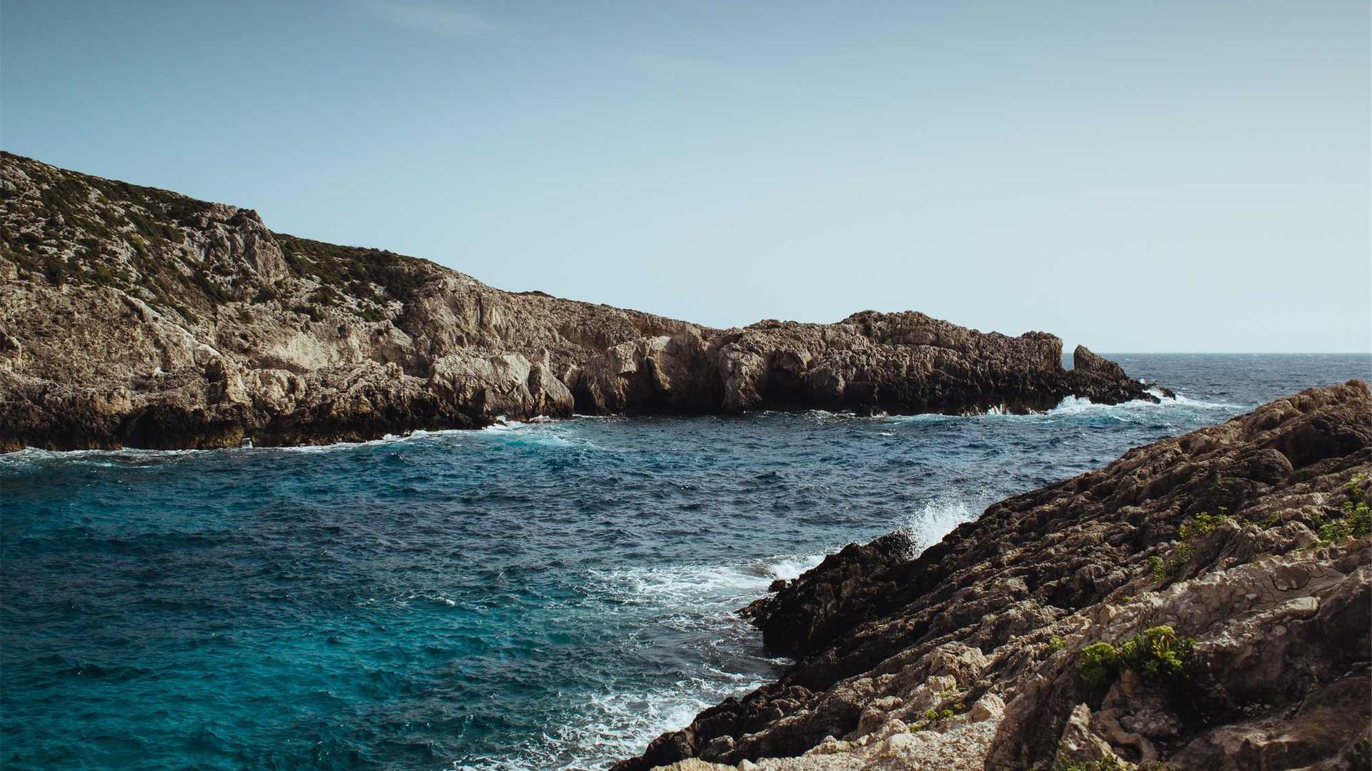 Choppy seas crash against rocky cliffs